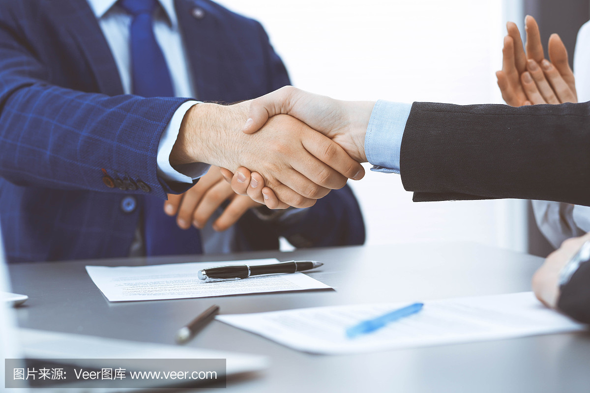 商人們握手,完成一份文件簽名。會(huì)議、合同及律師咨詢理念